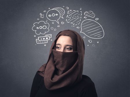 Young muslim woman wearing niqab with drawn speech bubbles above her head 