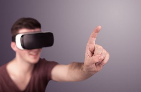 Young impressed man wearing virtual reality goggles