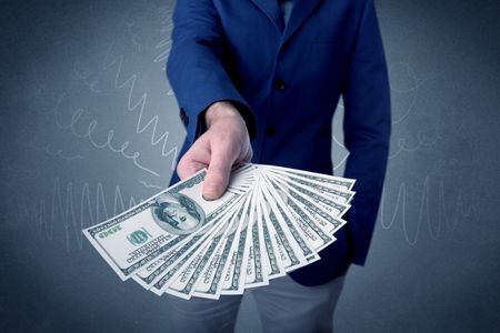 Young businessman holding large amount of bills with grungy background