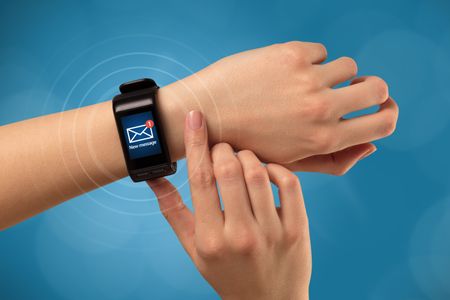 Female hand receives new message on her smartwatch