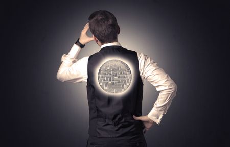 Businessman standing and thinking with maze graphic on his back