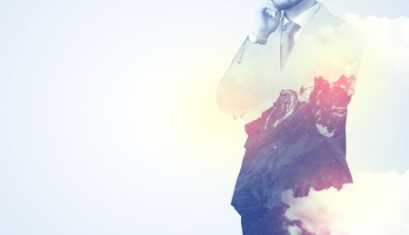 Businessman standing and thinking with snowy mountain graphic