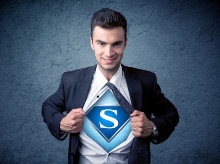 Businessman ripping off his shirt with superhero sign on his chest concept on background