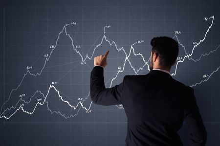 Young businessman in black suit standing in front of a progress chart