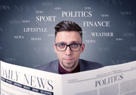 Young smart businessman reading daily newspaper