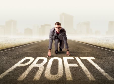 Young determined businessman kneeling before profit sign