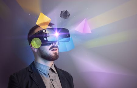 Amazed businessman with virtual reality colorful geometric shapes in front of him