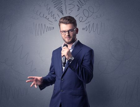 Businessman speaking into microphone with scribbles over his head