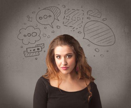 A cute female student making funny expressions with thoughts in her head illustrated by drawn chat bubbles on the urban wall background concept.