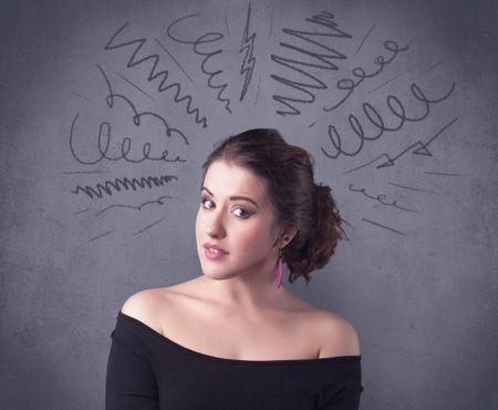 cute-female-student-making-funny-face-657536605 A cute female student making funny face expressions with pressure and problems in her head illustrated by drawn lines, marks and spirals on the urban wall background concept.