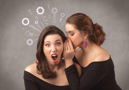 Two girlfriends in elegant black dress sharing secrets with each other concept with drawn rack cog wheels and spiral lines on the wall background.