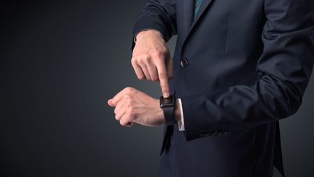 Man wearing suit with smartwatch on his wrist.