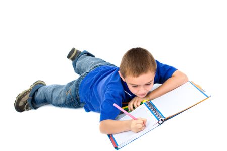 school boy doing homework on the floor isolated over a white background