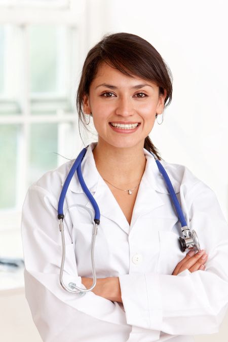 Young female doctor smiling - isolated over a white background