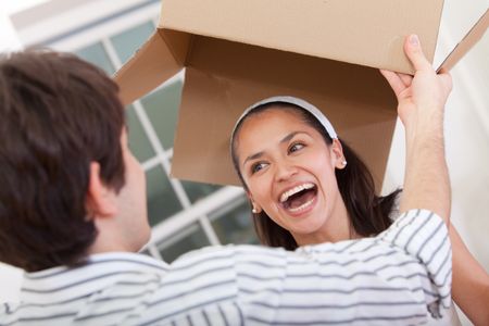 Happy couple with cardboard boxes moving to a new house
