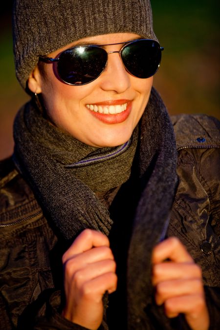 Autumn woman wearing sunglasses outdoors and smiling