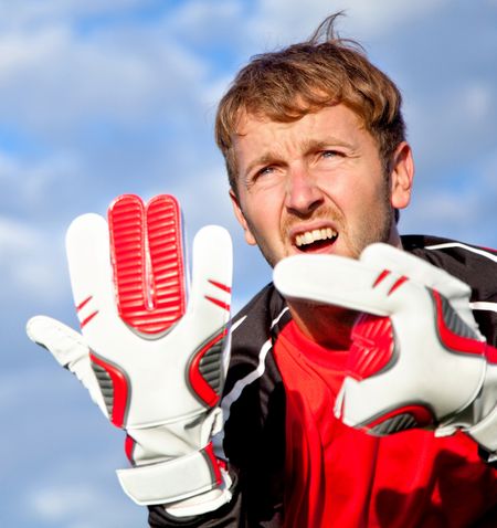 Football goalkeeper outdoors making signs with his hands