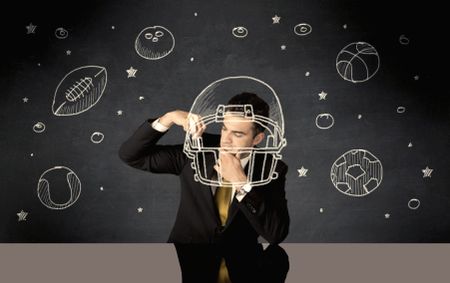 A happy college graduate dreaming about becoming a successful sports person while drawing helmet and ball in space concept