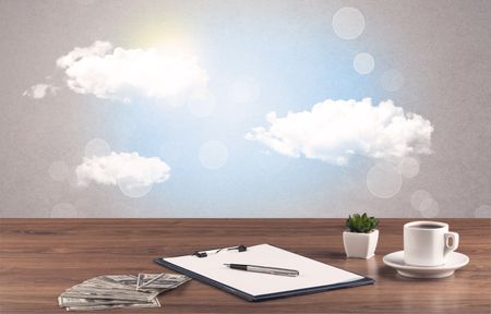 Close up of business office desk concept with clouds, blue sky and sunshine