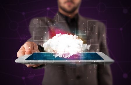 Businessman holding tablet with cloud icon and purple background
