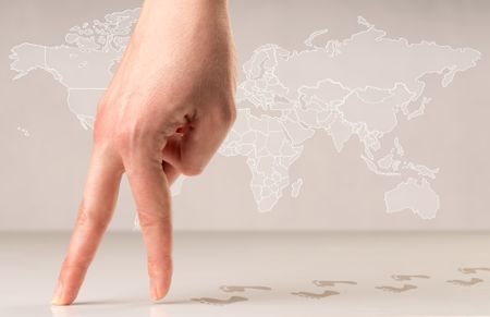 Female fingers walking with footsteps behind them and a world map in the background