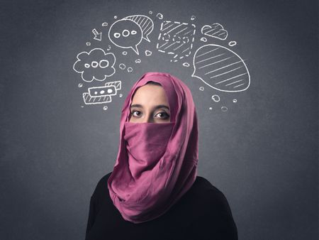 Young muslim woman wearing niqab with drawn speech bubbles above her head 