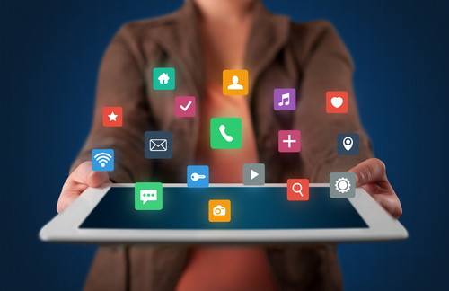 Casual young woman holding tablet with colorful applications 
