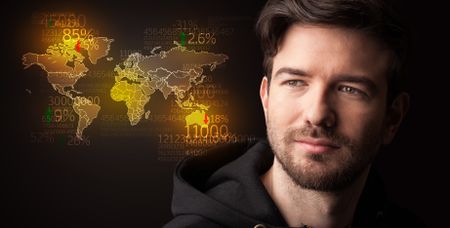 Portrait of a young businessman with a world map and numbers next to him on a dark background