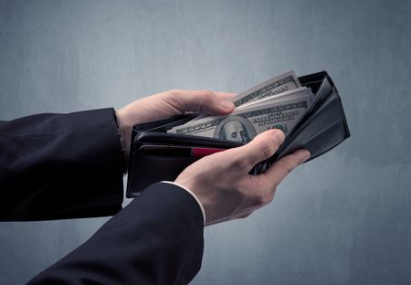 Businessman's hand in suit takes out dollar money from a wallet