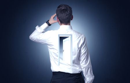 Young businessman standing and thinking with an open door on his back