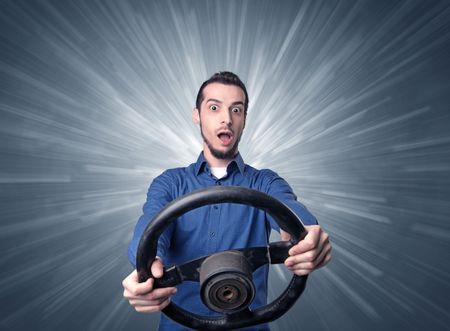 Young man holding black steering wheel with white lines behind him