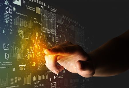 Female finger touching a beam of light surrounded by charts and graphs