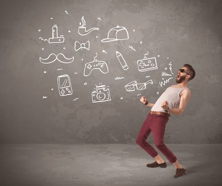 A funny hipster person in casual urban clothing shouting drawn everyday items like camera, tie or pen on city wall concept