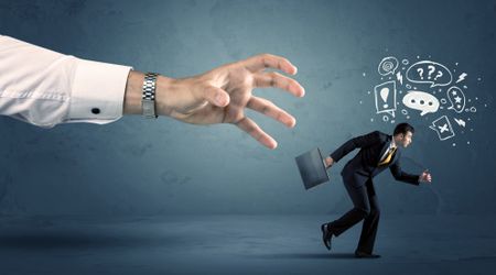 Business man with doodle icons running from a big hand concept on background