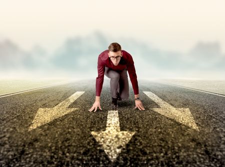 Young determined businessman kneeling before three arrows