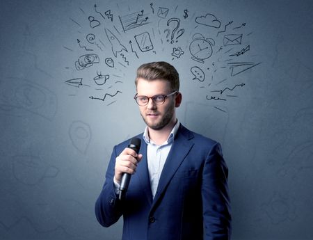 Businessman speaking into microphone with mixed doodles over his head