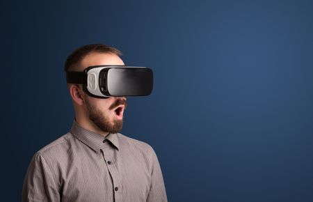 Amazed businessman with virtual reality goggles 