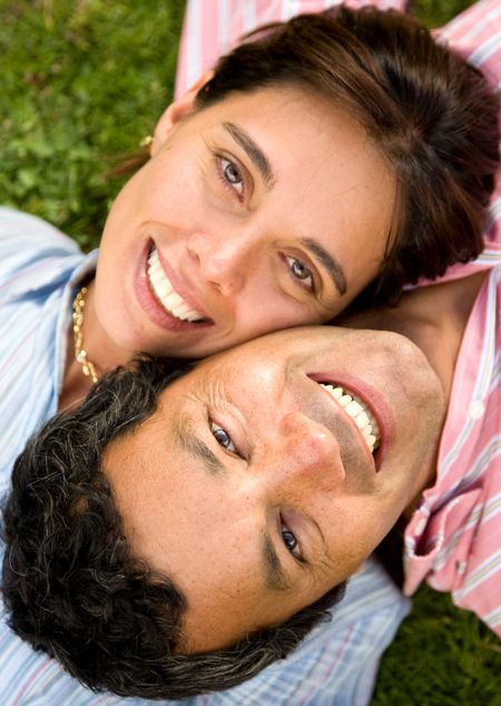 couple portrait on the floor outdoors where both are smiling and looking happy