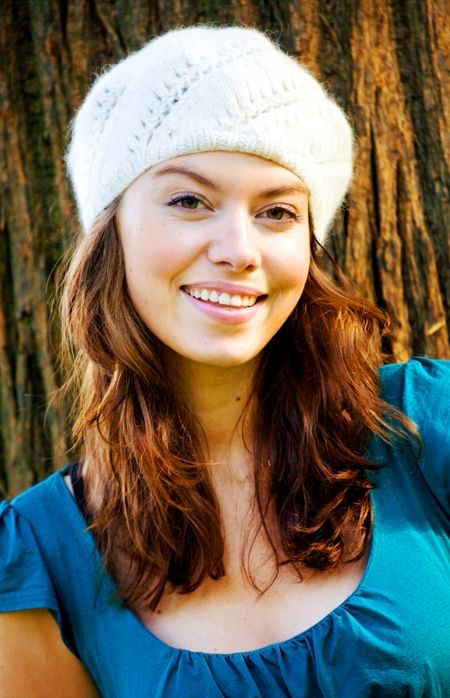 fashion girl portrait outdoors smiling and wearing a hat