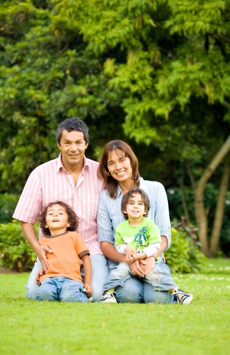 happy family portrait outdoors in a park with all smiling