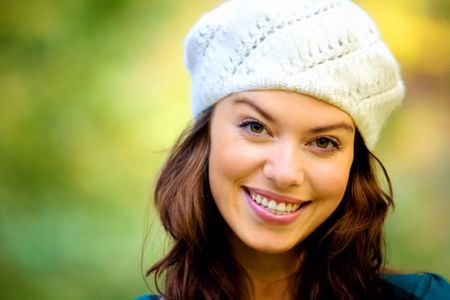fashion friendly girl portrait outdoors smiling and wearing a hta
