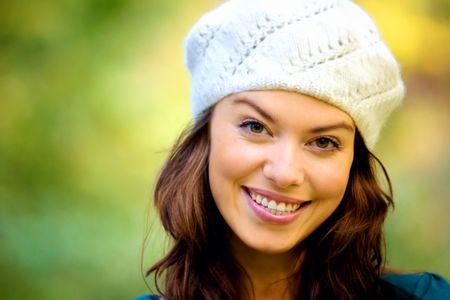 fashion friendly girl portrait outdoors smiling and wearing a hta