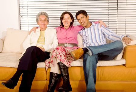 hispanic family portrait sitting on a sofa at home in a modern interior environment
