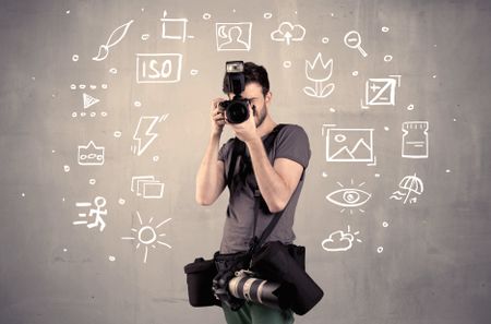 An amateur hobby photographer learning to use a professional digital camera with camera settings icons on the background wall concept