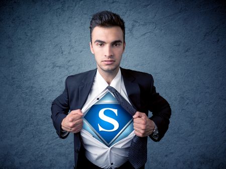 Businessman ripping off his shirt with superhero sign on his chest concept on background