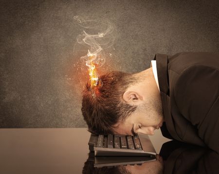 A frustrated businessman resting his head on a keyboard and shouting with his hair on smoke, catching fire