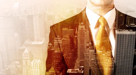 Business man looking at warm overlay city background