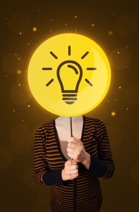 Casual young woman holding round sign with yellow lightbulb