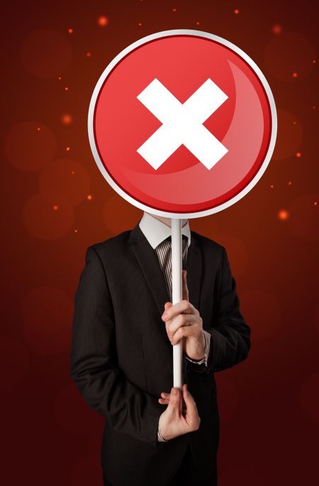 Smart businessman holding round red sign with a white cross 