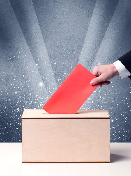 Ballot box with person casting vote on sparkling background